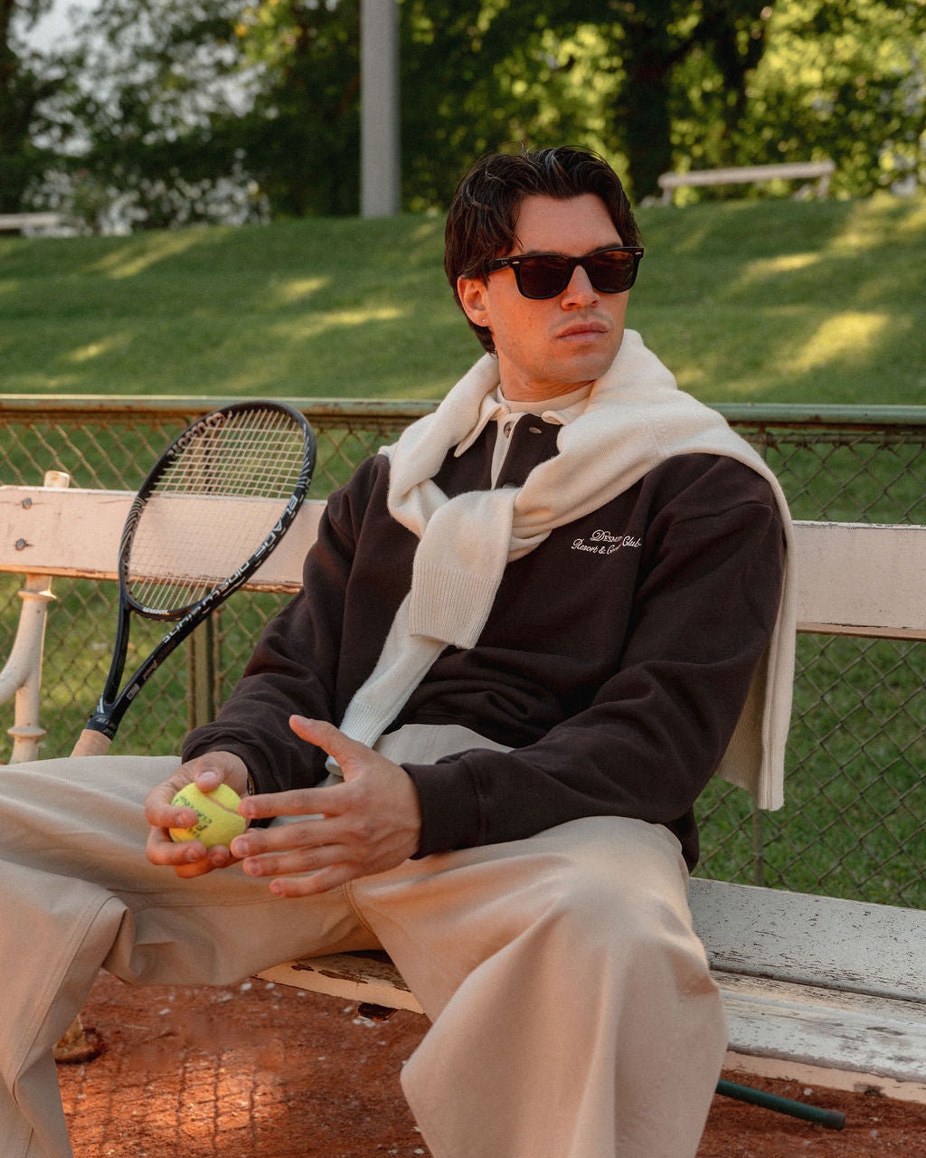 Close-up of the cream collar and button placket on the chocolate brown polo sweatshirt.